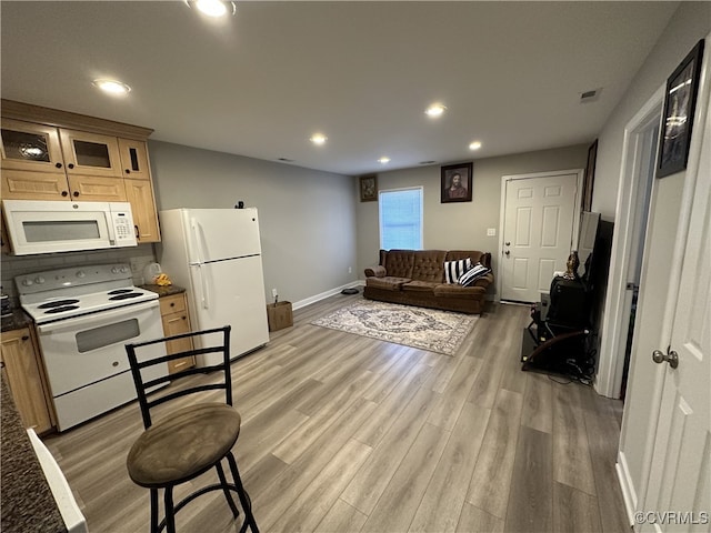 living room featuring light wood-type flooring, visible vents, baseboards, and recessed lighting