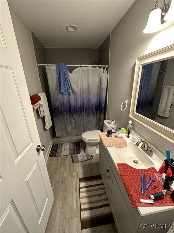 full bath featuring curtained shower, decorative backsplash, toilet, vanity, and wood finished floors