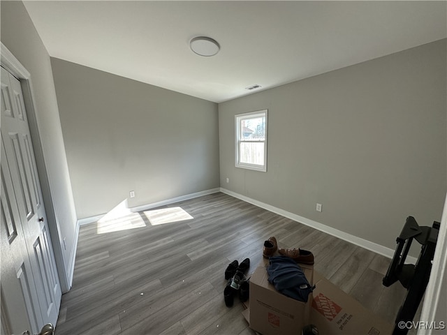 unfurnished bedroom featuring wood finished floors, visible vents, and baseboards