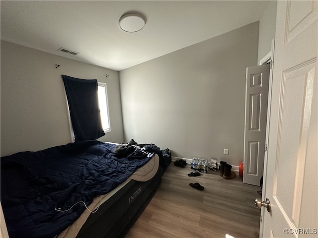 bedroom featuring light wood finished floors, baseboards, and visible vents