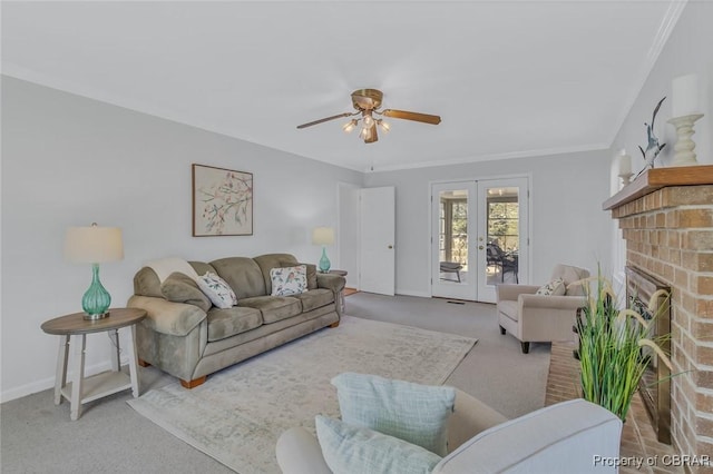 carpeted living area featuring french doors, a fireplace, crown molding, a ceiling fan, and baseboards