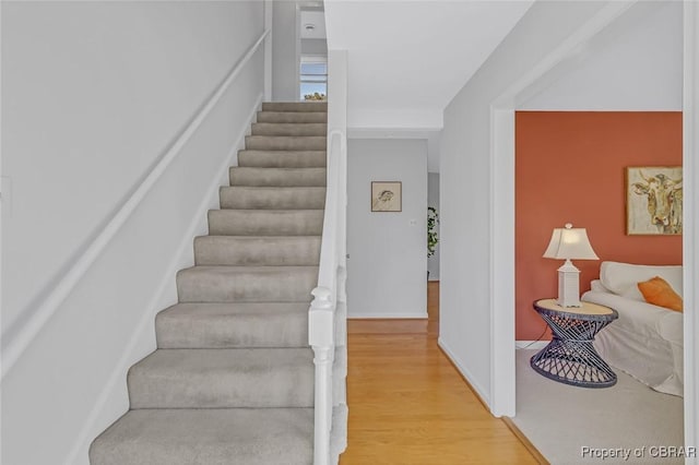 stairs with baseboards and wood finished floors