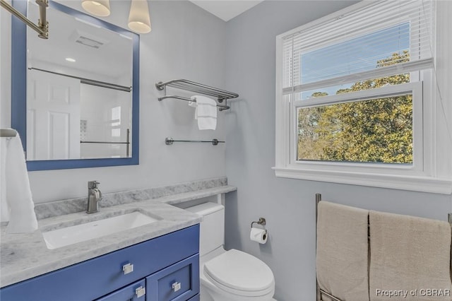 full bath featuring toilet, visible vents, a shower, and vanity