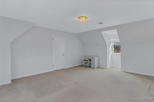 bonus room featuring lofted ceiling, light carpet, visible vents, and baseboards