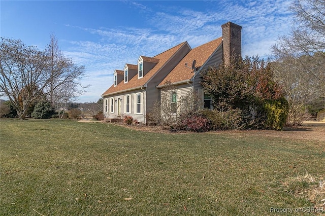 view of side of home with a lawn and a chimney