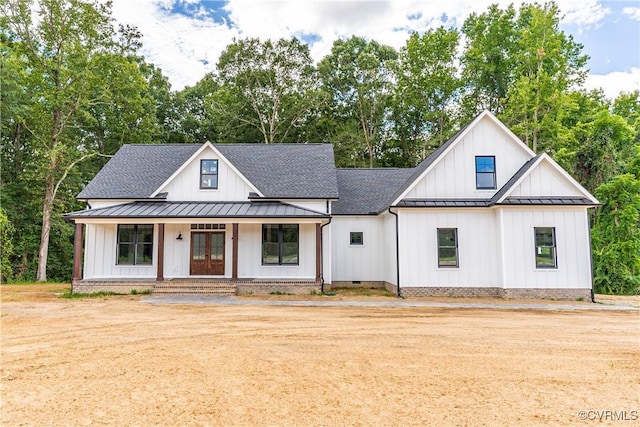 modern farmhouse with roof with shingles, a standing seam roof, and board and batten siding