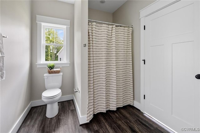 bathroom featuring curtained shower, wood finished floors, toilet, and baseboards