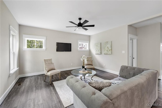 living room with visible vents, dark wood finished floors, baseboards, and ceiling fan