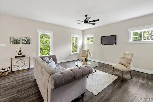 living room with dark wood-type flooring, a wealth of natural light, and baseboards