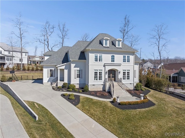 french country inspired facade featuring driveway, a shingled roof, crawl space, a front yard, and stucco siding