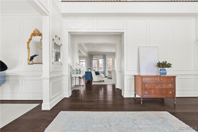 hall featuring ornamental molding, wood finished floors, and a decorative wall