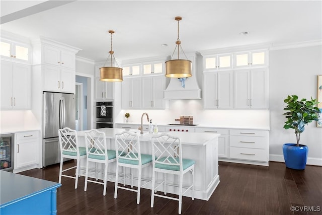 kitchen with dark wood finished floors, a breakfast bar area, stainless steel appliances, and light countertops