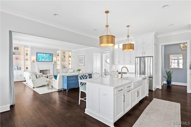 kitchen with a fireplace, a sink, light countertops, dark wood-style floors, and crown molding