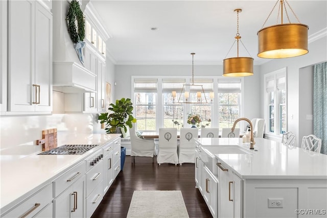 kitchen with dark wood-style flooring, crown molding, custom exhaust hood, light countertops, and white cabinets