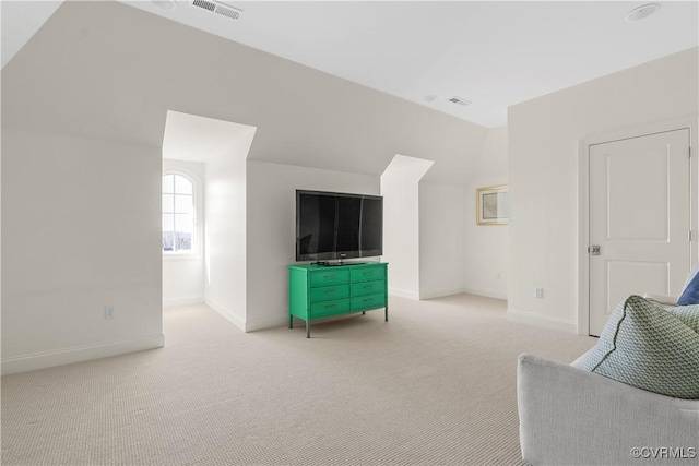 interior space featuring lofted ceiling, light carpet, visible vents, and baseboards