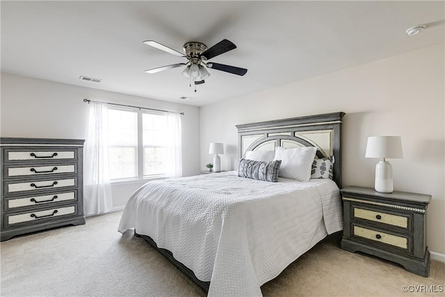 bedroom with visible vents, a ceiling fan, and light colored carpet