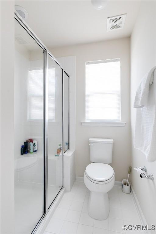 bathroom with baseboards, visible vents, a shower stall, and toilet