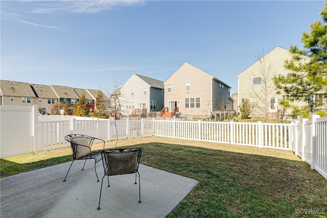 view of yard with a residential view, a fenced backyard, and a patio