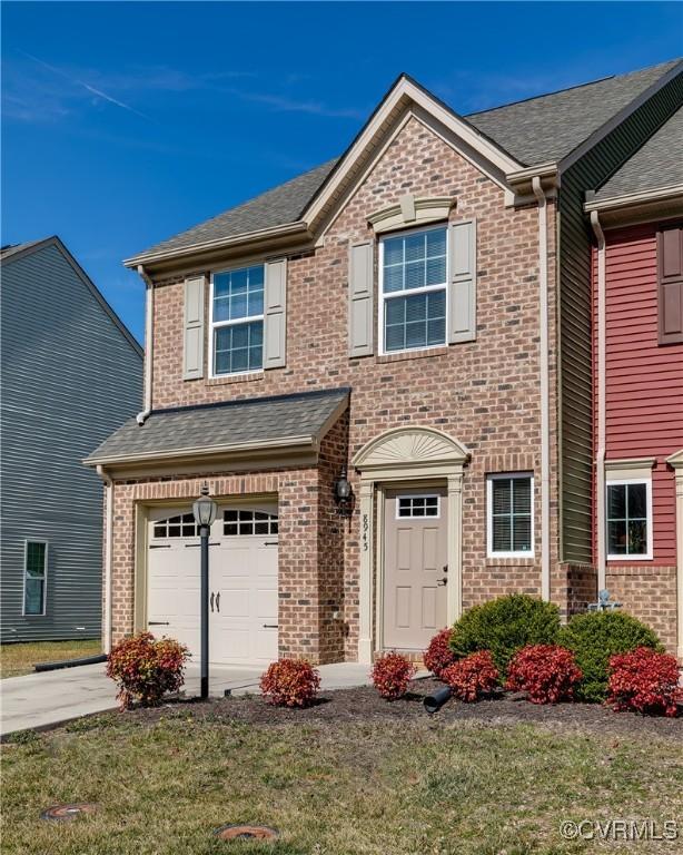 view of front of property with a garage, brick siding, a shingled roof, concrete driveway, and a front yard