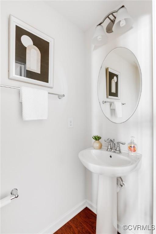 bathroom with wood finished floors and baseboards