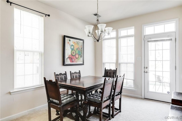 dining room with a chandelier, light colored carpet, visible vents, and baseboards