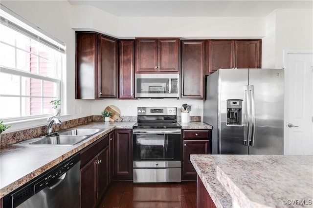 kitchen with stainless steel appliances, a sink, and dark wood-style floors