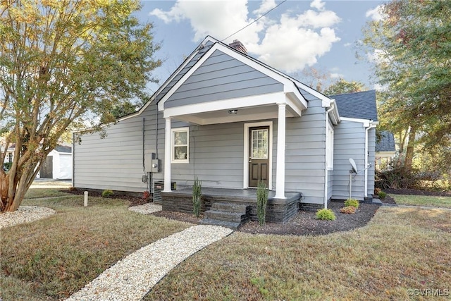 view of front of home featuring a porch, a front yard, and a shingled roof