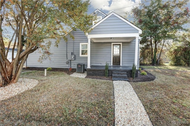 view of front of house with covered porch, central AC, and a front yard