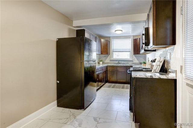 kitchen with marble finish floor, stainless steel appliances, backsplash, a sink, and baseboards