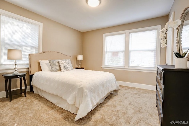 bedroom with light carpet and baseboards