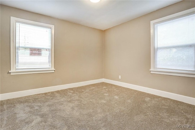 empty room featuring carpet floors and baseboards