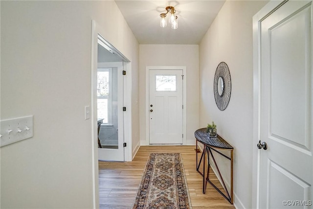 doorway to outside featuring light wood finished floors and baseboards