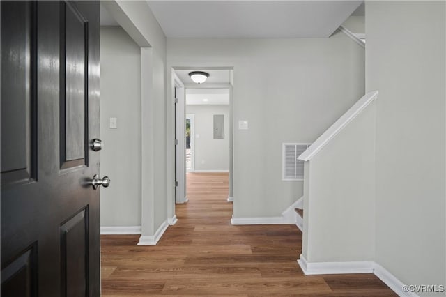 entryway with baseboards, stairs, visible vents, and wood finished floors