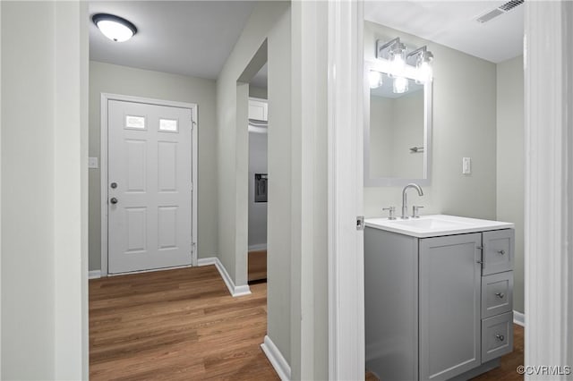 bathroom with baseboards, visible vents, wood finished floors, and vanity