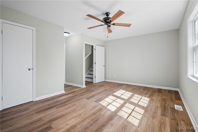 unfurnished bedroom with wood finished floors, visible vents, and baseboards