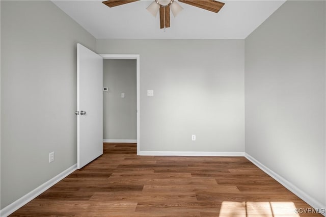 spare room featuring ceiling fan, light wood-type flooring, and baseboards