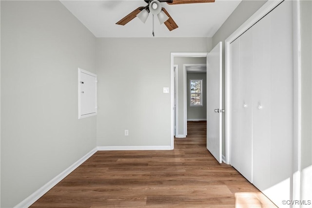 unfurnished bedroom with light wood-style floors, ceiling fan, baseboards, and a closet