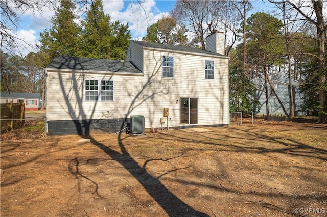 back of property featuring a chimney and central AC unit