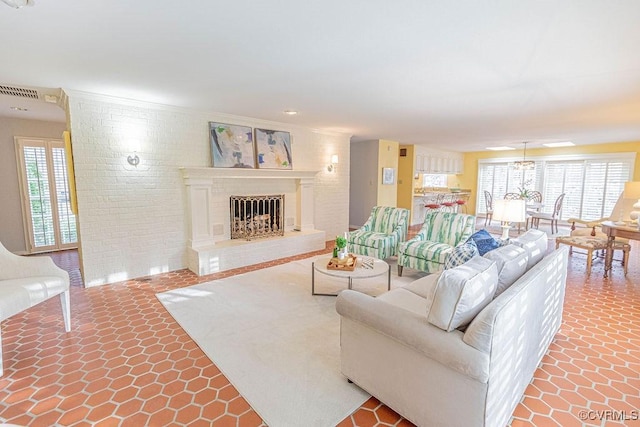 living area featuring a healthy amount of sunlight, brick wall, and a fireplace