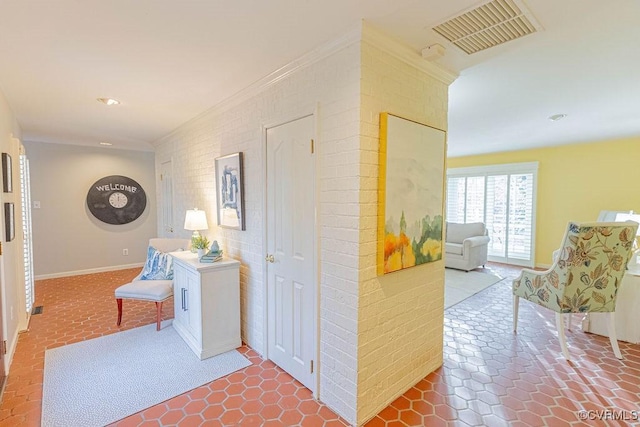 corridor with visible vents, recessed lighting, brick wall, crown molding, and baseboards