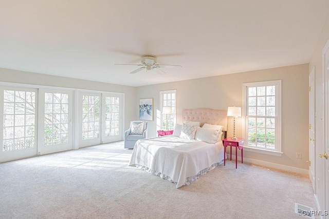 bedroom with ceiling fan, access to exterior, baseboards, and light carpet