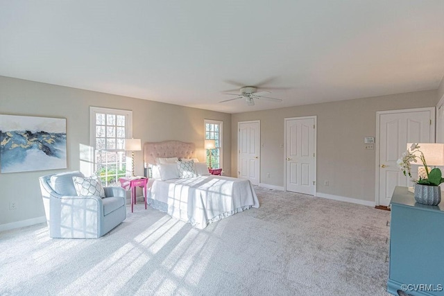 carpeted bedroom with ceiling fan, baseboards, and multiple closets