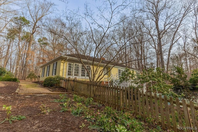 view of side of home featuring a fenced front yard and stucco siding