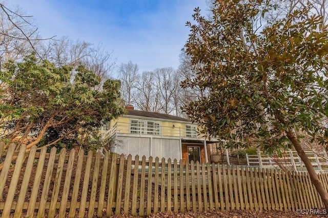 view of front facade with a fenced front yard and a chimney