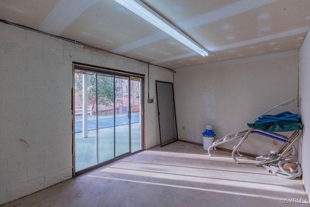 spare room with concrete floors and concrete block wall