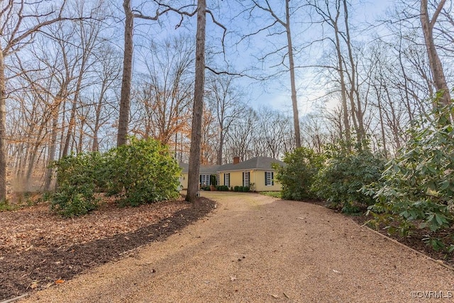 view of front of property featuring driveway and a chimney