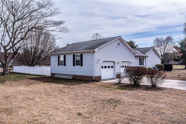 view of front of house featuring a garage, concrete driveway, and fence