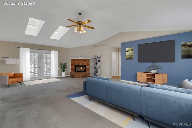 living area with light carpet, lofted ceiling, french doors, a fireplace, and baseboards