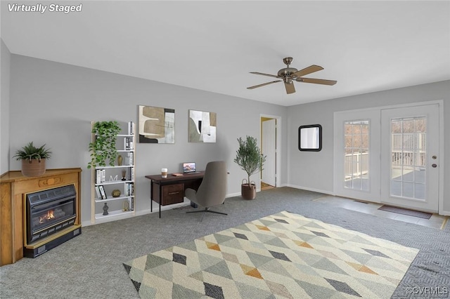 carpeted home office featuring a glass covered fireplace, baseboards, and ceiling fan