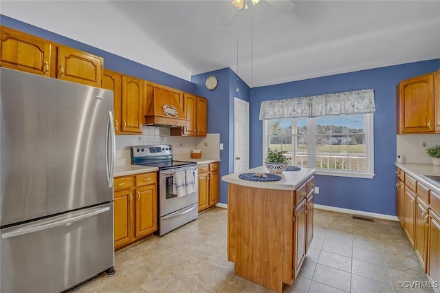 kitchen with a kitchen island, light countertops, decorative backsplash, appliances with stainless steel finishes, and custom exhaust hood